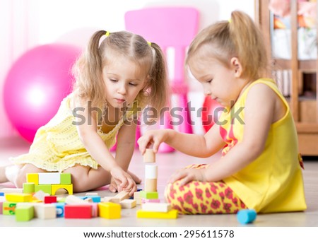 children playing wooden toys at home or kindergarten