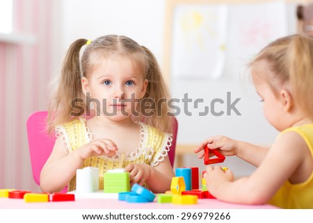 children girls play educational toys in preschool