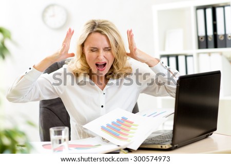 Stressed business woman at laptop in office