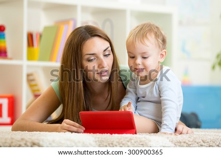 mother and son child play with tablet pc indoors
