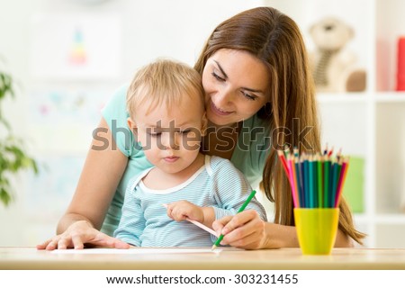 Mother helping her kid son to make drawings