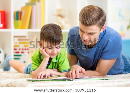 cute little boy and his dad read book together