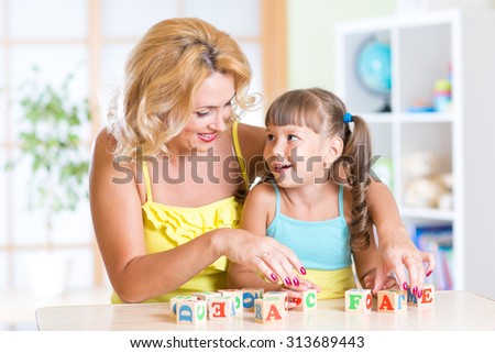kid plays building blocks with parent at home