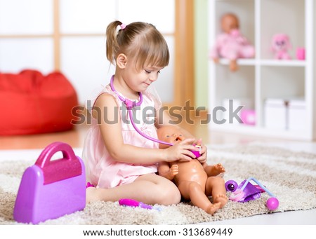 child girl playing doctor with toy at home