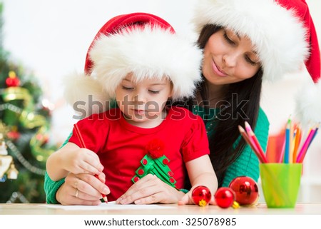 Child girl and her mother writing letter to Santa