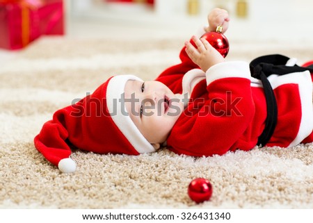 Baby boy weared Santa costume hollding christmas ball