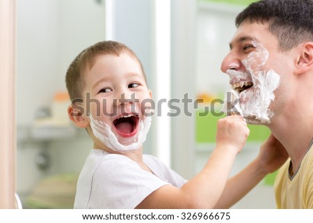 playful father and his kid son shaving and having fun in bathroom
