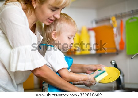 Mother teaches her little child kid son to wash-up