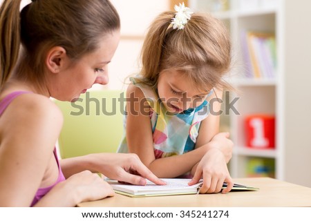 Mother teaching her child daughter to read