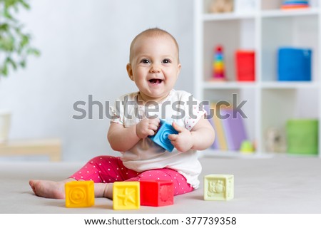 baby toddler playing color toys at home or nursery