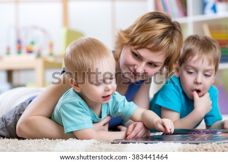 Cute mother and her two sons children reading together