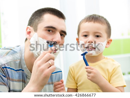Father shaving in the mirror. Kid son imitates father