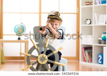 Child pretend to be sailor. Little boy looking through spy glass playing at home.