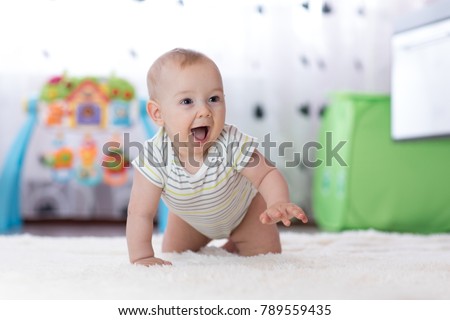 crawling funny baby boy in nursery at home