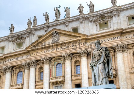 Sculpture of st. Paul with the St. Peter\'s basilica seen from st. Peter\'s square in the Vatican