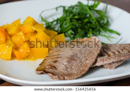 Grilled meat with pumpkin and ruccola
