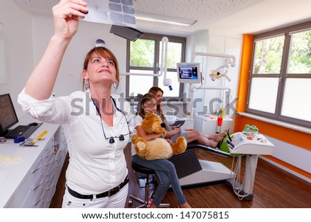 A dentistry doctor looks a x-ray picture in a doctor-surgery