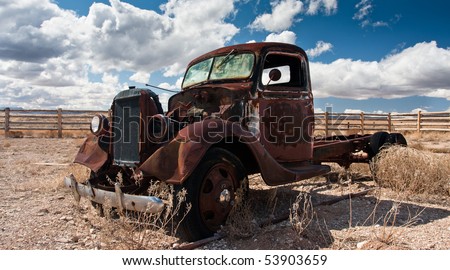 Rustbucket truck abandoned in junkyard field