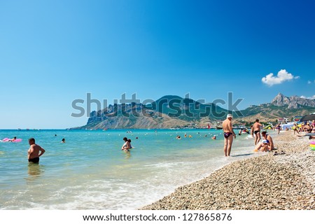 KOKTEBEL, UKRAINE - JULY 5: People swim and sunbathe at the city beach of Koktebel  on July 5, 2012 in Koktebel, Ukraine. The beach is one of the most popular holiday resorts in Crimea, Ukraine.