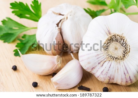garlic with parsley leaves on a wooden table