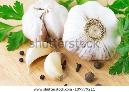 garlic with parsley leaves on a wooden table