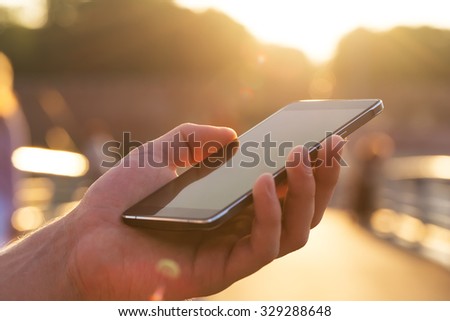 Man using his Mobile Phone outdoor, close up
