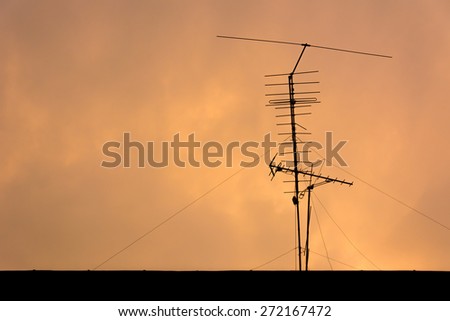 Silhouette view of television antenna under sunset sky