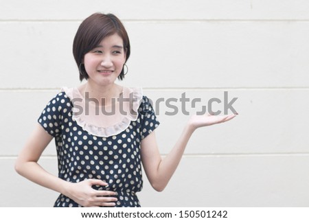 Asian young woman with abdominal pain showing product or text