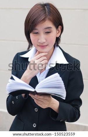 Asian Business Woman looking at a note book