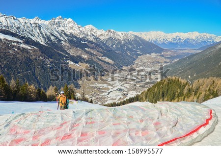 INNSBRUCK, AUSTRIA - MARCH 14: A man in paragliding suit at Alp mountain, Innsbruck, Austria on March 14, 2012. Innsbruck belongs to one of the best winter sports regions of the Alps.