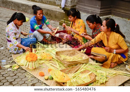 BALI, INDONESIA - OCT 17: Balinese woman preparing for doing offering on October 17, 2013 on Bali, Indonesia. Hindu daily offering is a tradition of Balinese.