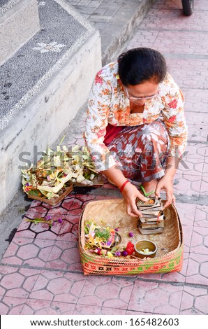 UBUD, INDONESIA-OCT 17: unidentified woman praying god in Ubud, Bali, Indonesia, on 17 October 2013. Every morning women bring flowers and incense to their gods
