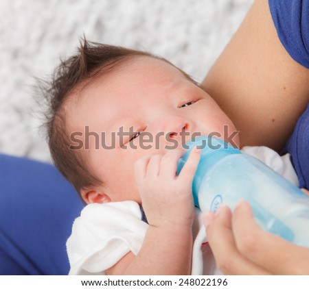 mother feeds the baby bottle