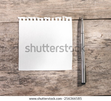 Note pad or memo pad on an old grungy wooden board or surface.