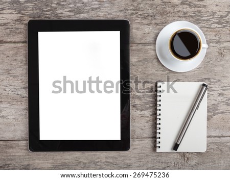 empty tablet with note paper and coffee on the wooden table