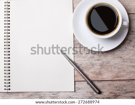 notepad ans a cup of coffee on a wooden desktop