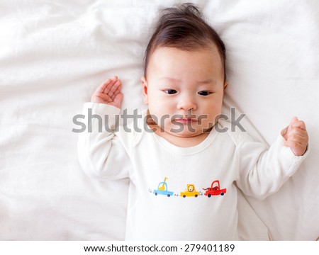 asian baby lay down on bed