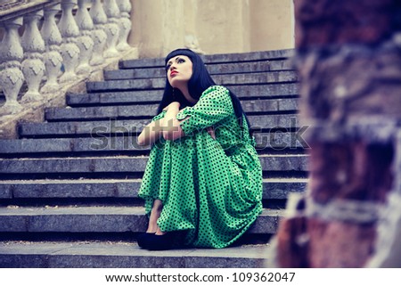 Woman on the old stairs in green dress