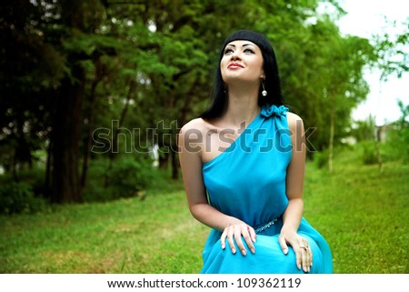 Happy lady in dress in summer garden smilling