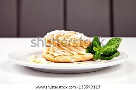 Pastry with sugar powder, almonds and mint on white background