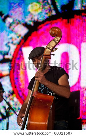 SOPRON, HUNGARY - JUN 30: Double bass player play on doublebass on the Radio MR2 stage before the lighting wall with the logo of the Volt Festival on Jun 30, 2011 in Sopron, Hungary.