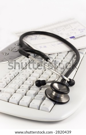 Stethoscope and medical record lying on a keyboard. Focus on the foreground.