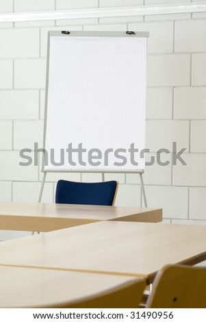 White empty billboard in a meeting room with tables and chairs