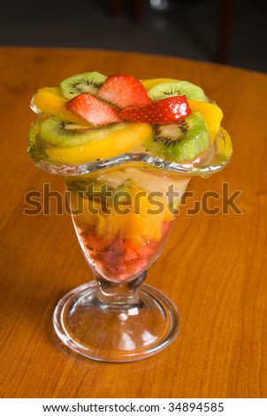 The fruit dessert in grass (kiwi, strawberries, apple, peach)