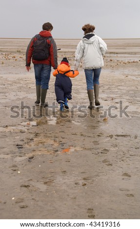 Three persons (woman, man and boy) in a rubber boots