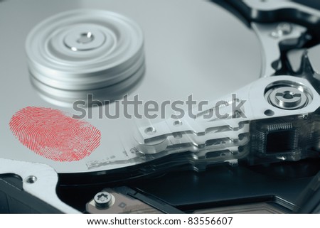 Hard disk drive with red fingerprint on surface. The read write head is moving. It is a symbol for personal data.