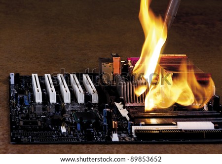 burning computer part on rusty background. modern mainboard overheated
