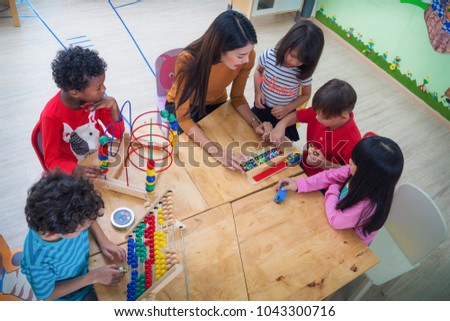 Teacher and student in an international preschool play a toy togather, this concept can use for eduction, kid, student, bob, work and teacher concept