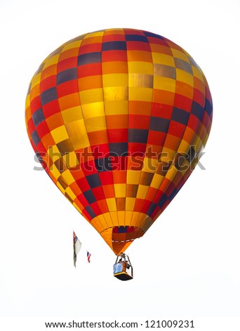 A red hot air balloon rises above the treetops during Colorado\'s Balloon Classic