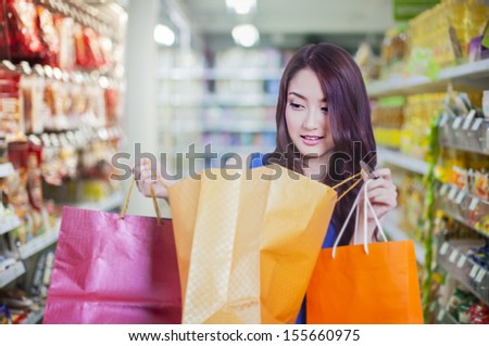 asian lady with shopping bag in supermarket